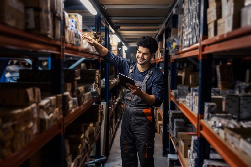 Warehouse worker scanning product barcodes using an inventory management mobile system.